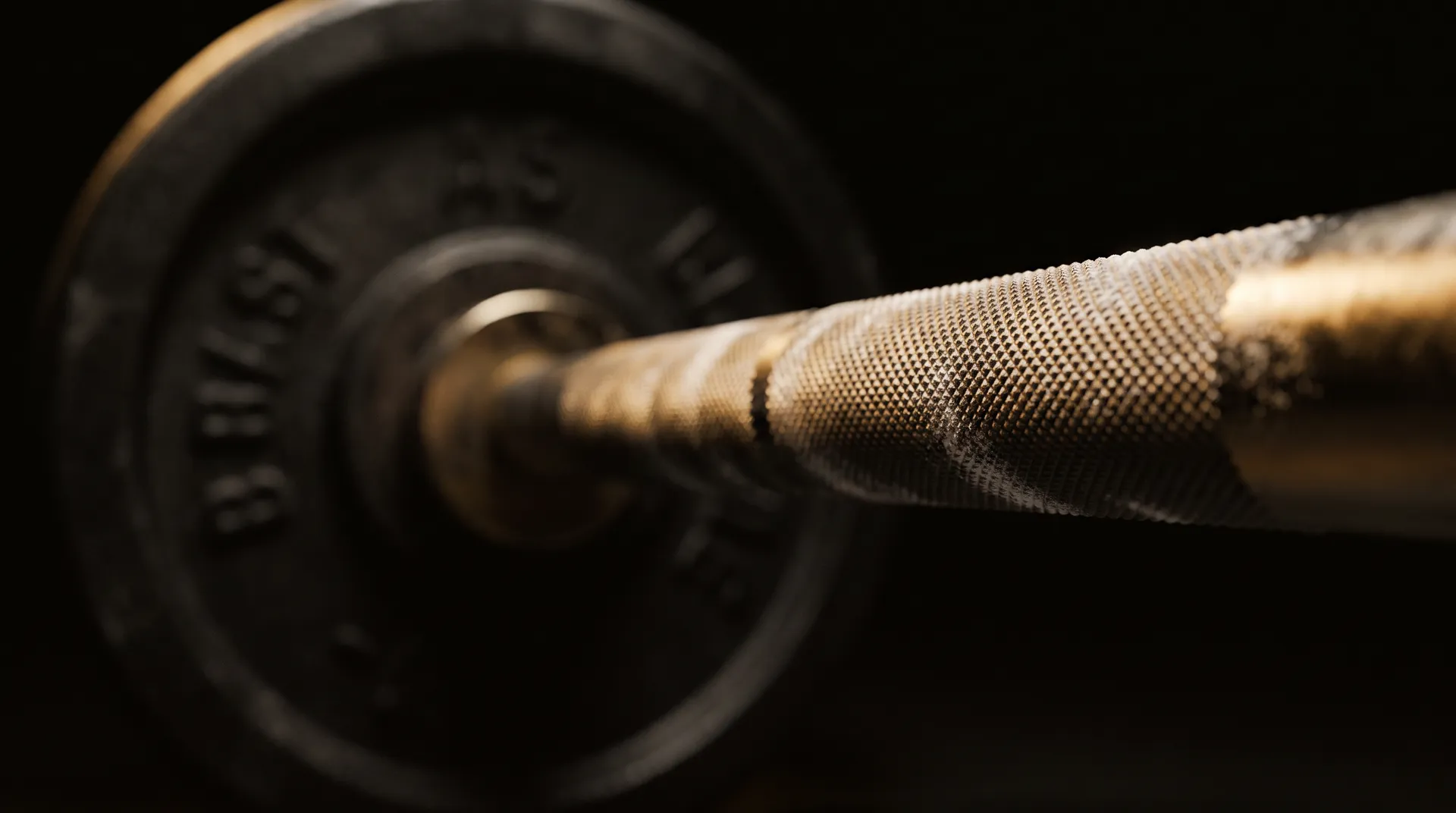 Moletage d'une barre olympique couvert de craie, éclairé à l'or